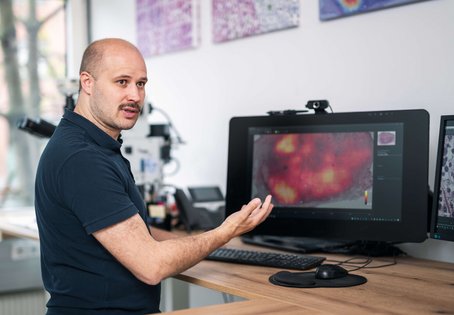 Christof Bertram steht vor einem Bildschirm und erklärt eine Heatmap