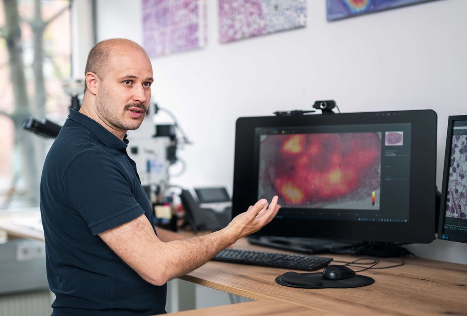 Christof Bertram steht vor einem Bildschirm und erklärt eine Heatmap