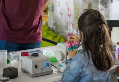 Kleines Mädchen mit Probenröhrchen aus dem Chemielabor