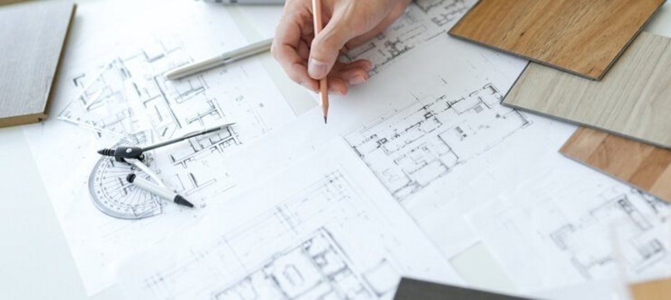 Jemand schreibt auf einen Raumplan