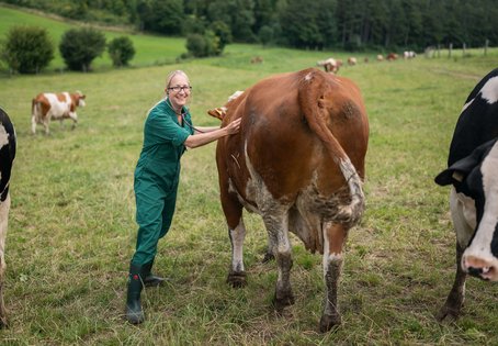 Melanie Sch&auml;ren Bannert lacht und horcht ein Rind mit einem Stethoskop ab.
