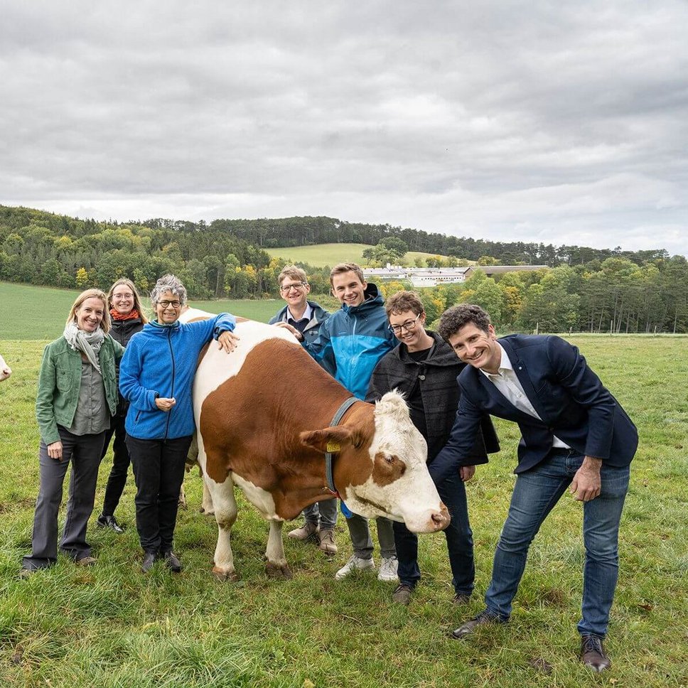 Menschen mit Kuh auf Weide