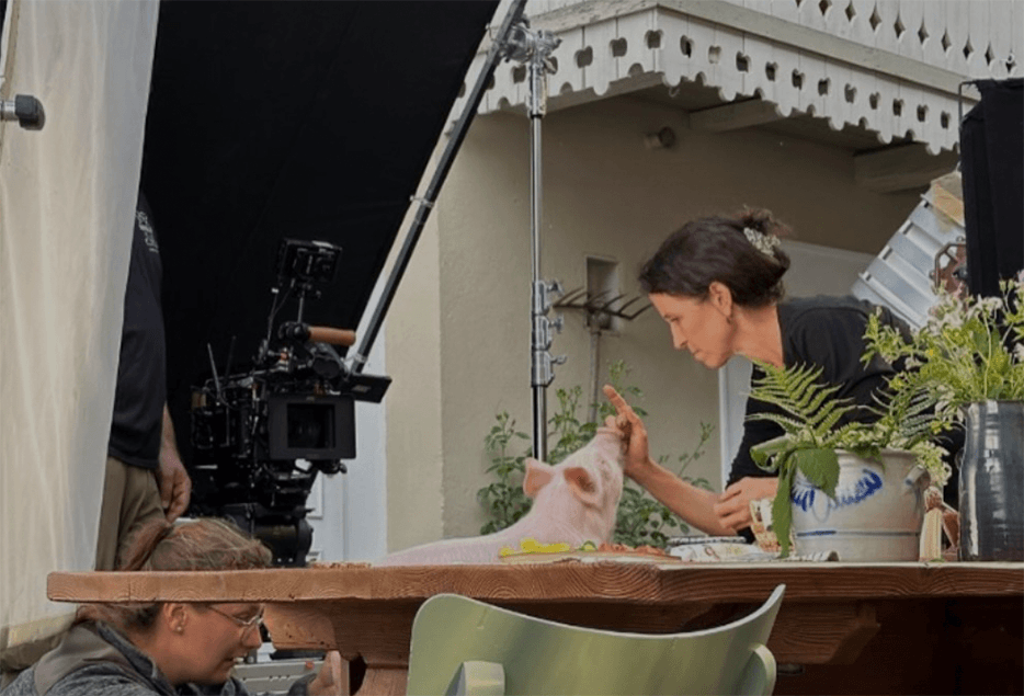 Katja Hawliczek arbeitet mit einem Ferkel am Filmset.
