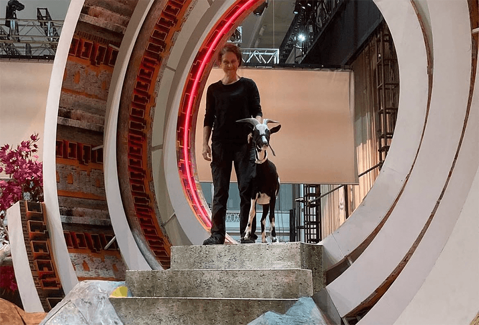 Katja Hawliczek begleitet eine Ziege w&auml;hrend eines Drehs am Filmset.